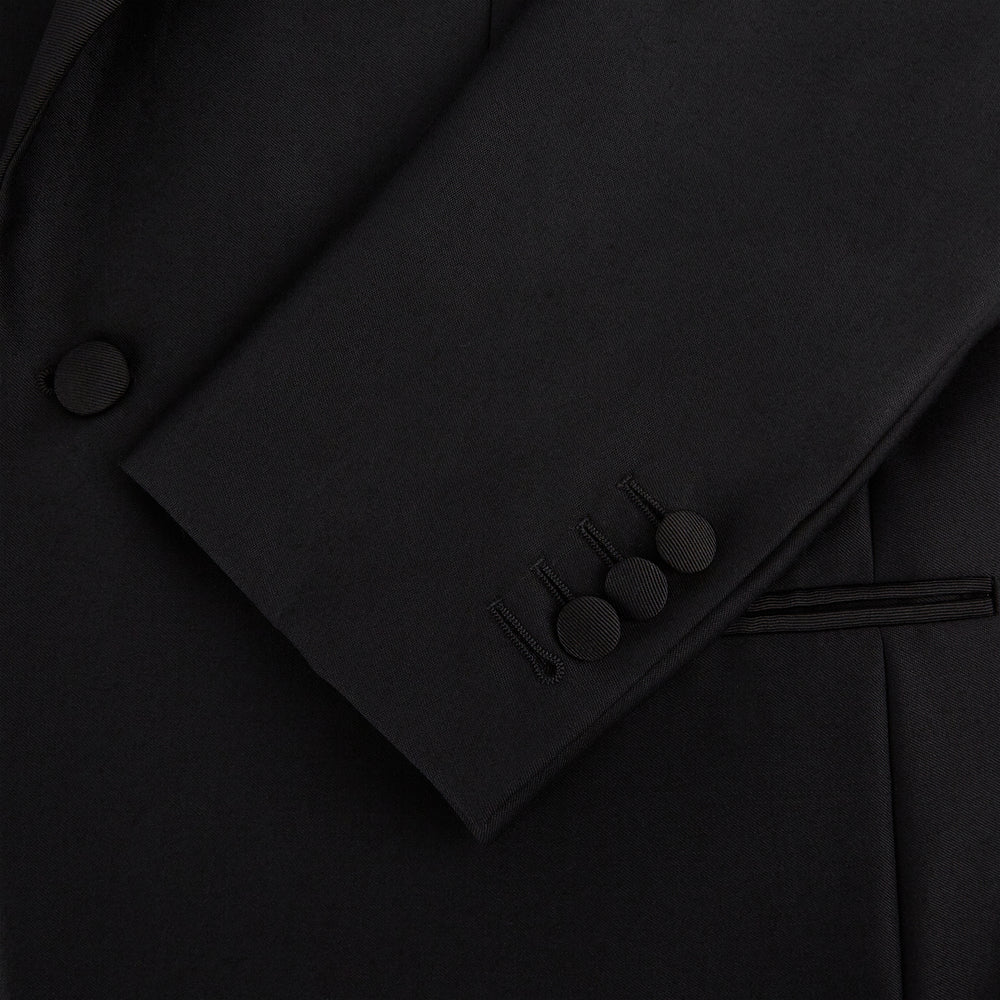 The Turnbull & Asser Black Single Breasted Dinner Suit, with satin lapels and matching trousers, is elegantly folded and displayed on a plain white background.