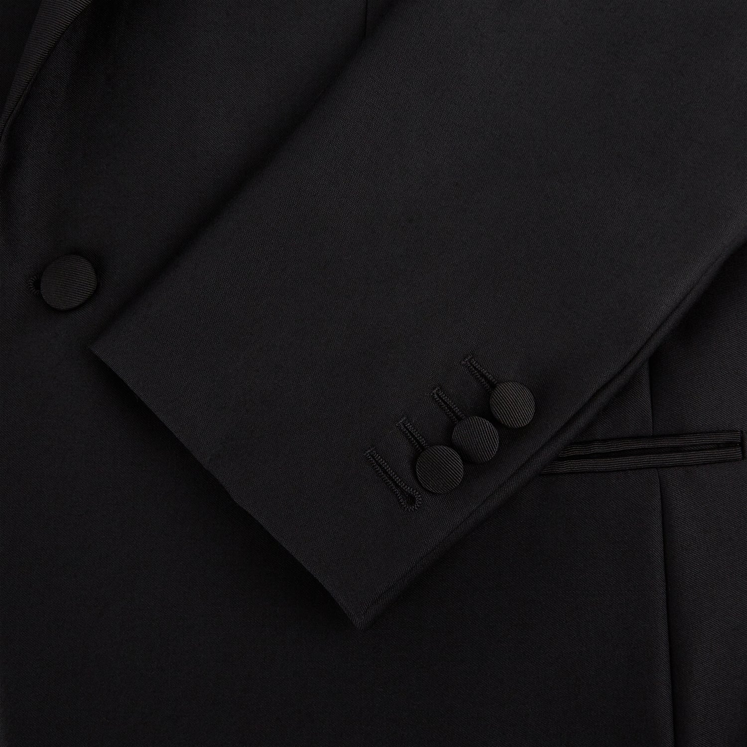View 7 of product The Turnbull & Asser Black Single Breasted Dinner Suit, with satin lapels and matching trousers, is elegantly folded and displayed on a plain white background.