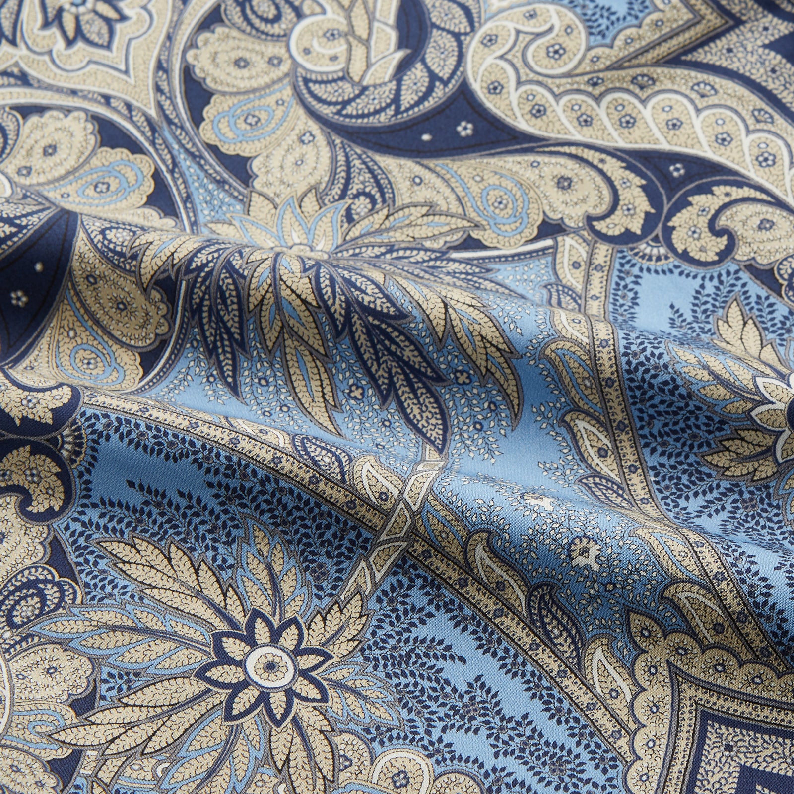 View 3 of product The Turnbull & Asser Pale Blue Baroque Silk-blend Hyde Pyjama Set features a long-sleeve button-up shirt and pants in a blue and beige paisley pattern, shown flat on a white background.