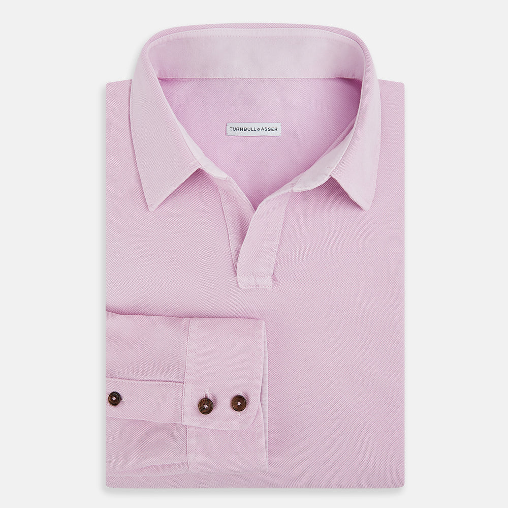 The Pink Rugby Polo Shirt by Turnbull & Asser features long sleeves, a collar, and V-neck opening in luxury cotton, shown flat on a white background.