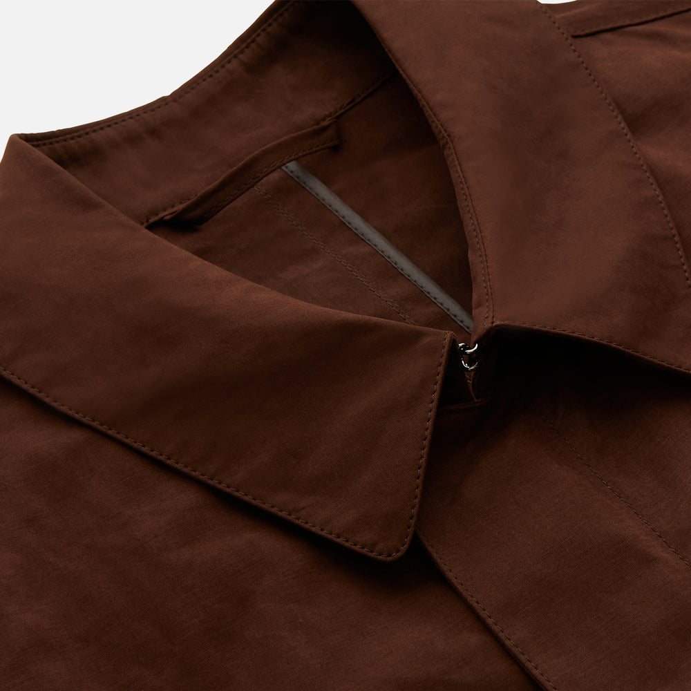 The Burgundy Grayson Car Coat by Turnbull & Asser, made from a rain-resistant cotton blend with a collar, hidden front buttons, and slanted pockets, is displayed flat on a white background in a minimalist style.
