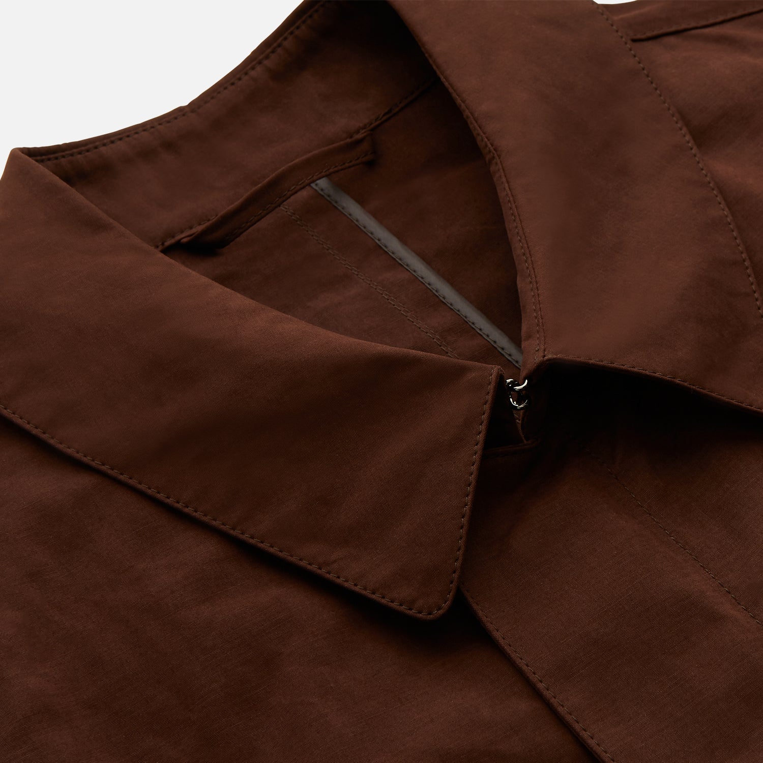 View 4 of product The Burgundy Grayson Car Coat by Turnbull & Asser, made from a rain-resistant cotton blend with a collar, hidden front buttons, and slanted pockets, is displayed flat on a white background in a minimalist style.