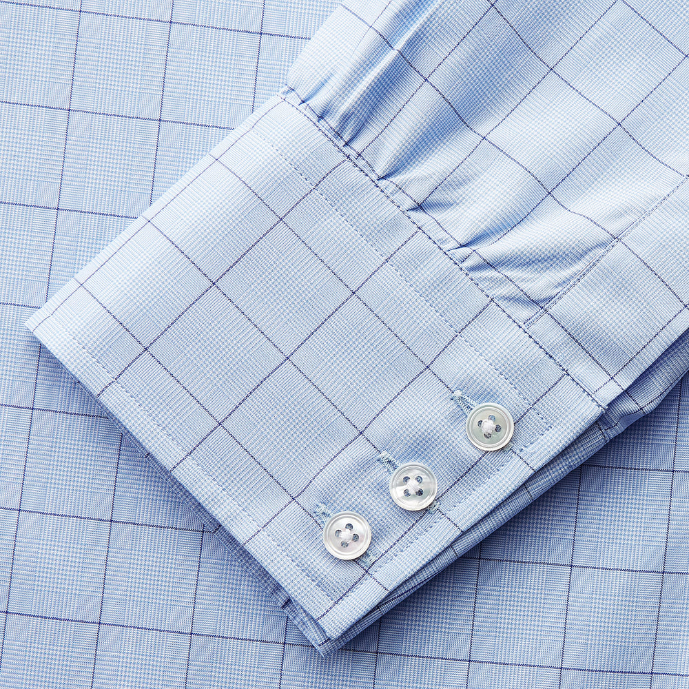 The Blue Prince of Wales Check Mayfair Shirt by Turnbull & Asser features a light blue check pattern, white buttons, and a classic collar. Crafted from premium Italian cotton, it is displayed on a plain white background.