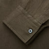 View 3 of product The Turnbull & Asser Khaki Green Linen Weekend Fit Langston Shirt features long sleeves, a classic Derby collar, two chest pockets, and buttoned cuffs, shown against a white background.