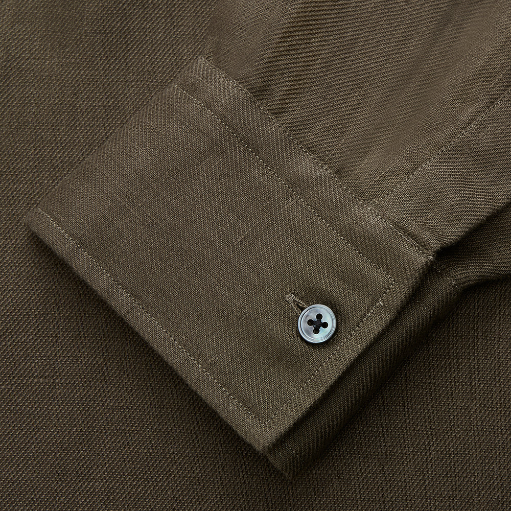 The Turnbull & Asser Khaki Green Linen Weekend Fit Langston Shirt features long sleeves, a classic Derby collar, two chest pockets, and buttoned cuffs, shown against a white background.