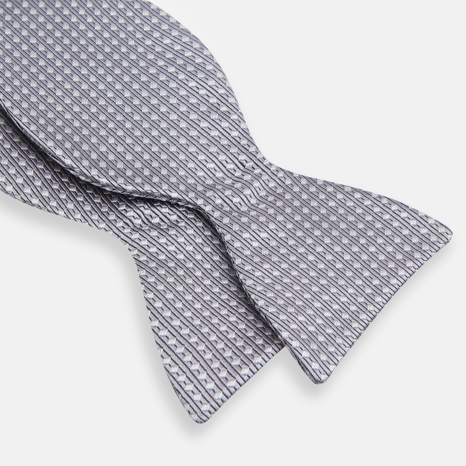 View 3 of product The Turnbull & Asser Silver and White Square Silk Bow Tie features a subtle geometric pattern, ideal for formalwear, and is displayed against a plain white background.