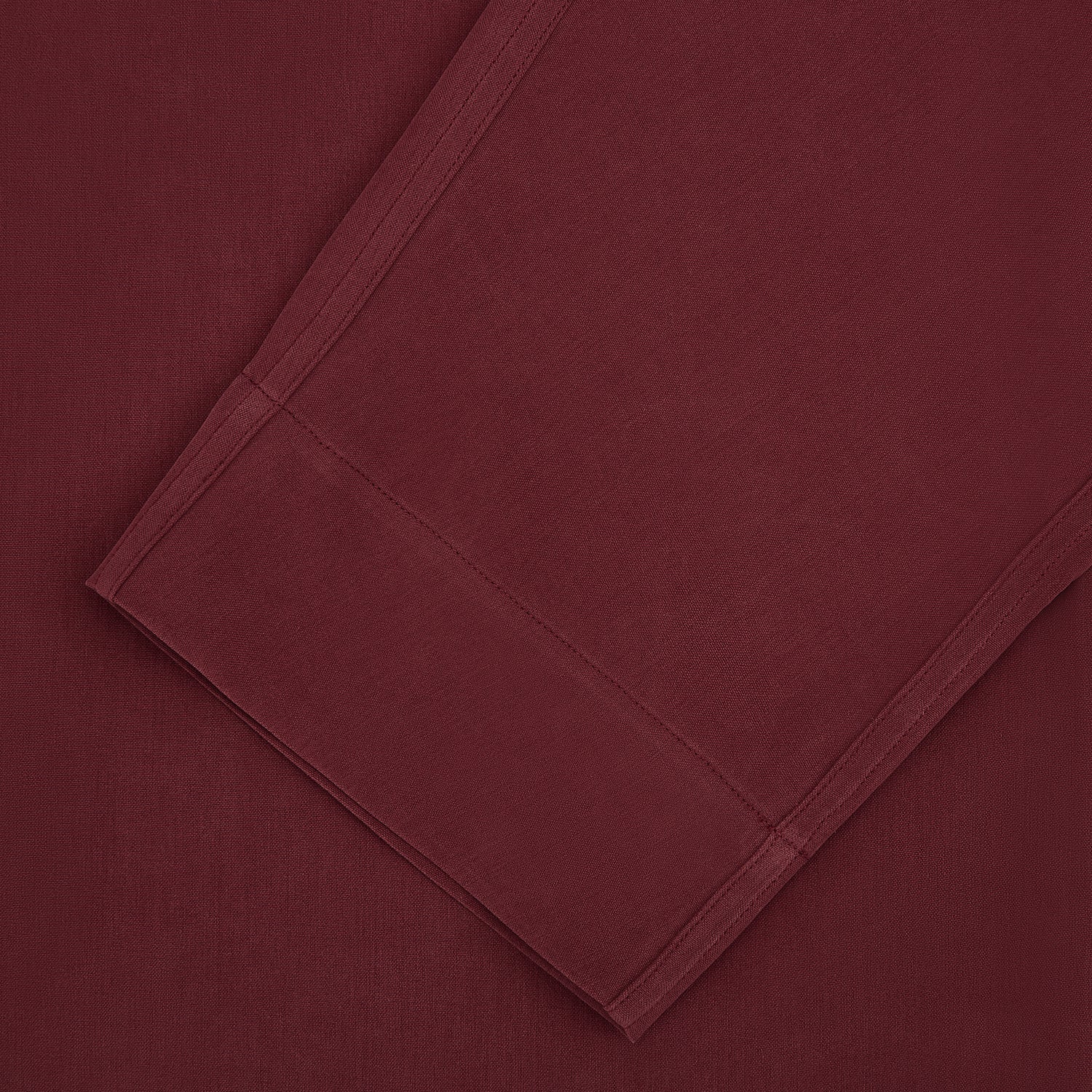 View 3 of product The Turnbull & Asser Burgundy Silk Pyjama Set features a long-sleeve, button-up shirt with chest pocket and matching pants with elastic waistband and side pocket, shown on a white background.