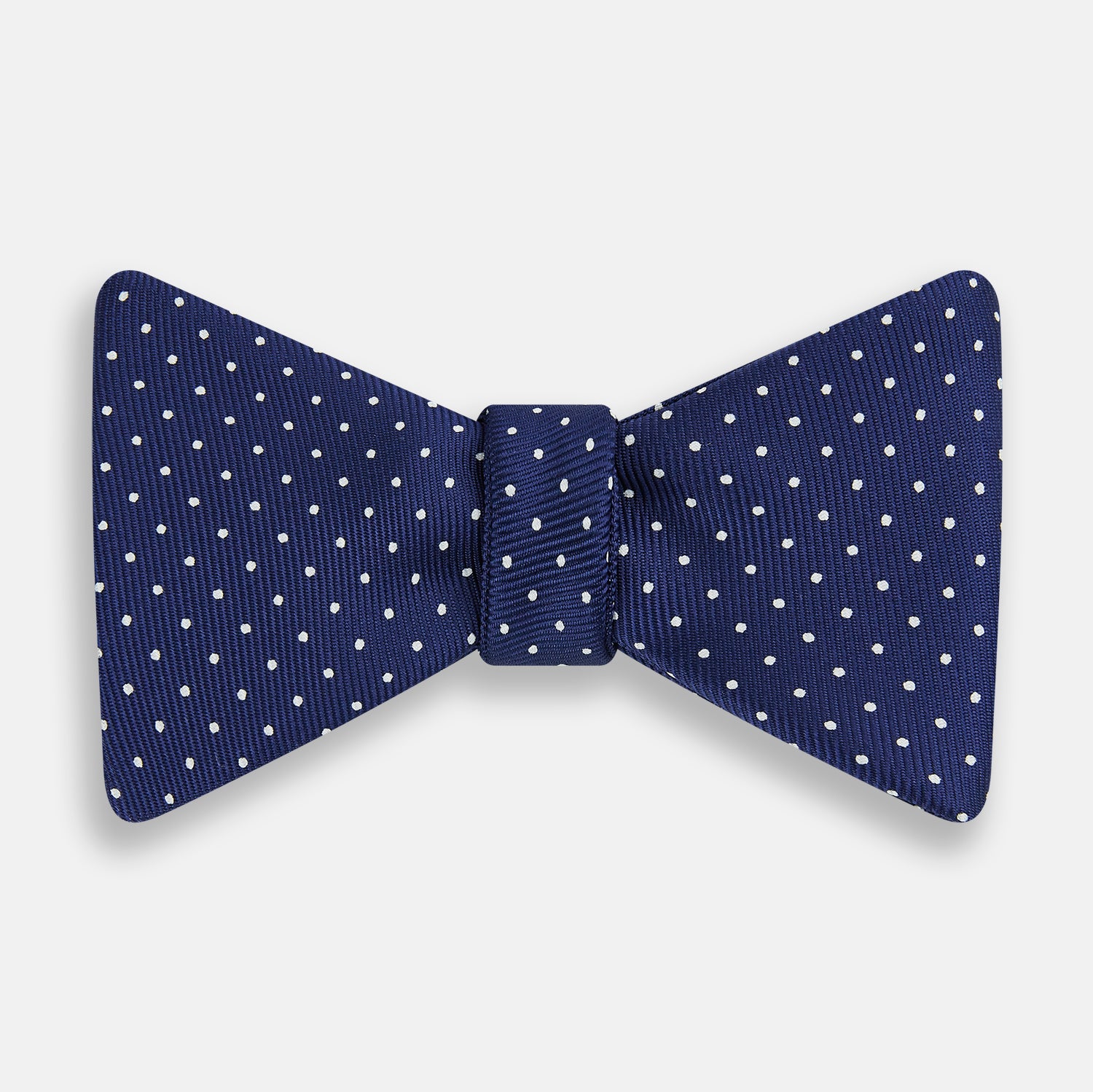 View 1 of product The Turnbull & Asser Azzurro and White Spot Silk Bow Tie features a classic blue silk design with small white spots, shown elegantly against a plain white background.