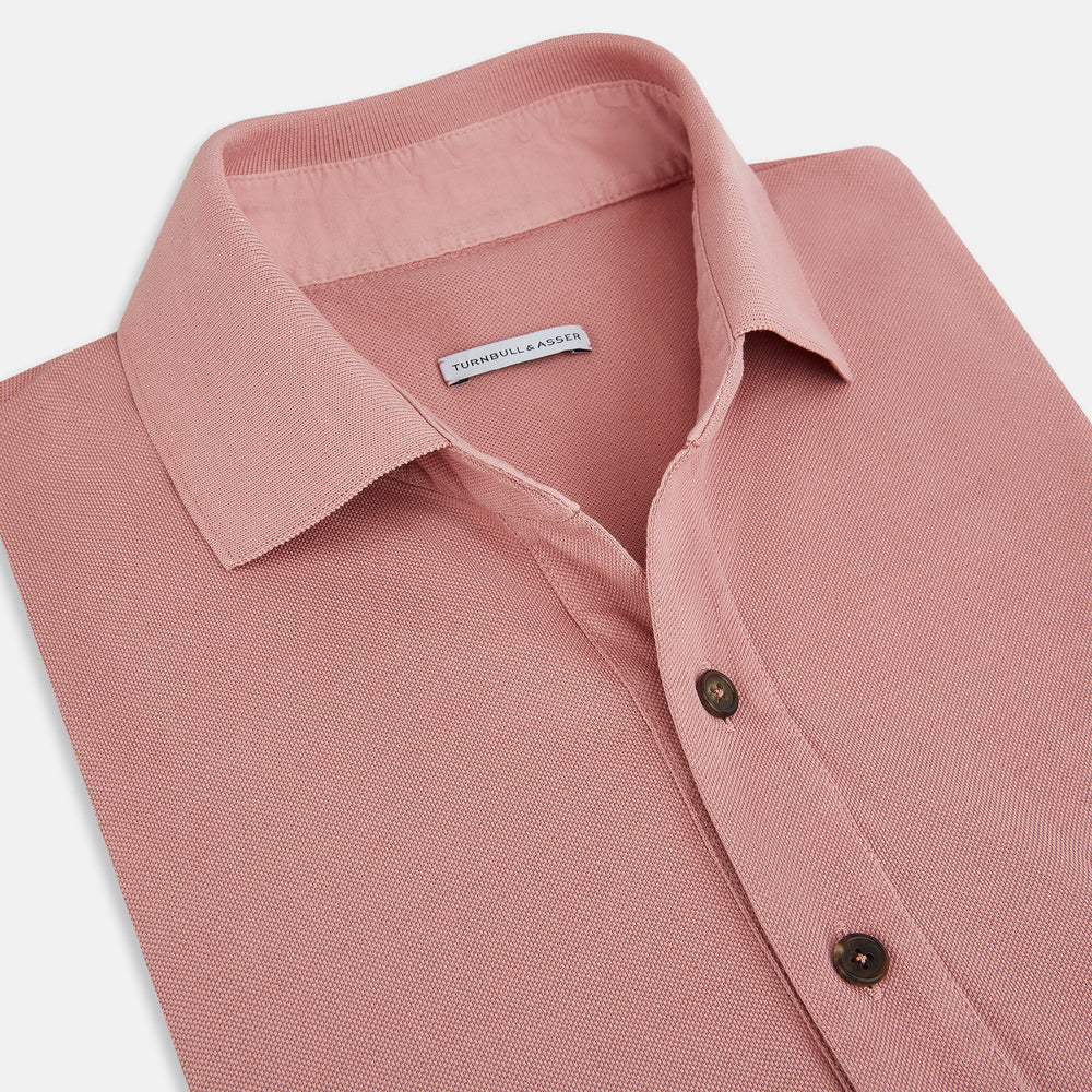 The Turnbull & Asser Red Polo Shirt is a men's cotton polo with short sleeves, a collar, a three-button neckline, and a buttoned chest pocket. The shirt is shown laid flat on a white background.
