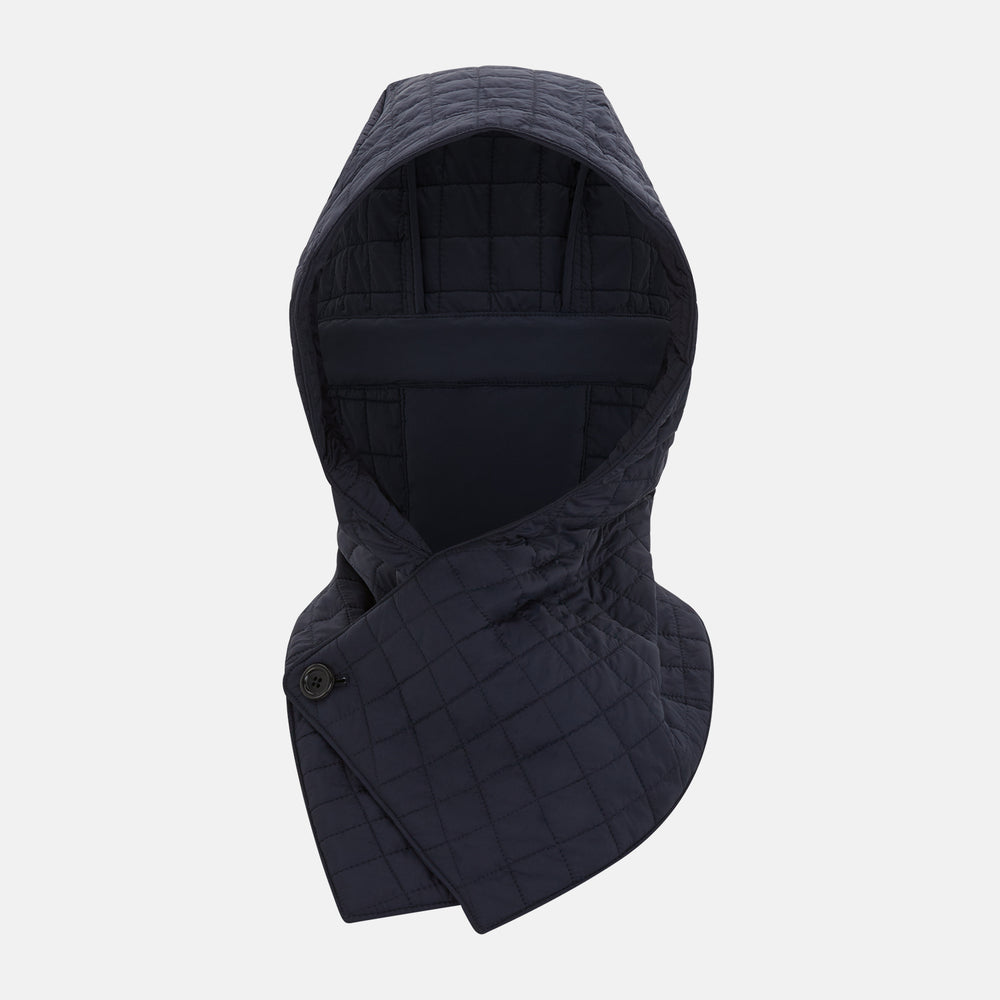 The Turnbull & Asser Navy Quilted Hood with Neck Warmer features diamond pattern stitching, a structured hood, overlapping collar, and button closure, shown on a plain white background.