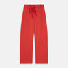 View 6 of product The Turnbull & Asser Women's Coral Pink Silk Thelma Pyjama Set features a long-sleeve button-up top with two front pockets and matching drawstring pants, shown on a white background.