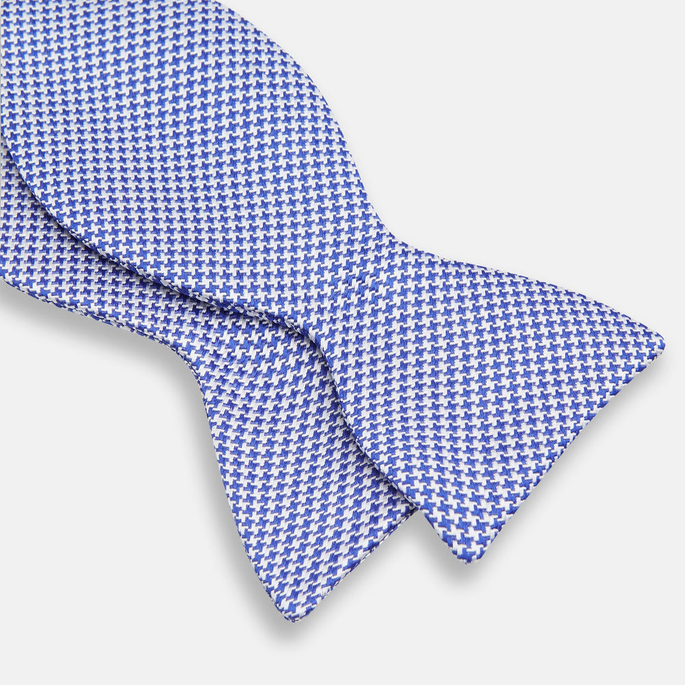 The Turnbull & Asser Navy and White Houndstooth Silk Bow Tie features a neatly centered knot, shown on a white background—an elegant formalwear accessory.