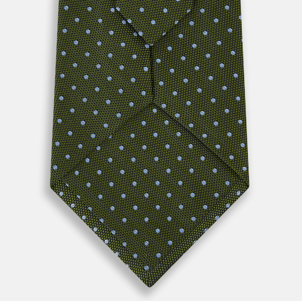 The Turnbull & Asser Green and Blue Micro Dot Silk Tie is shown rolled up, displaying small light blue dots on green silk against a plain white background.