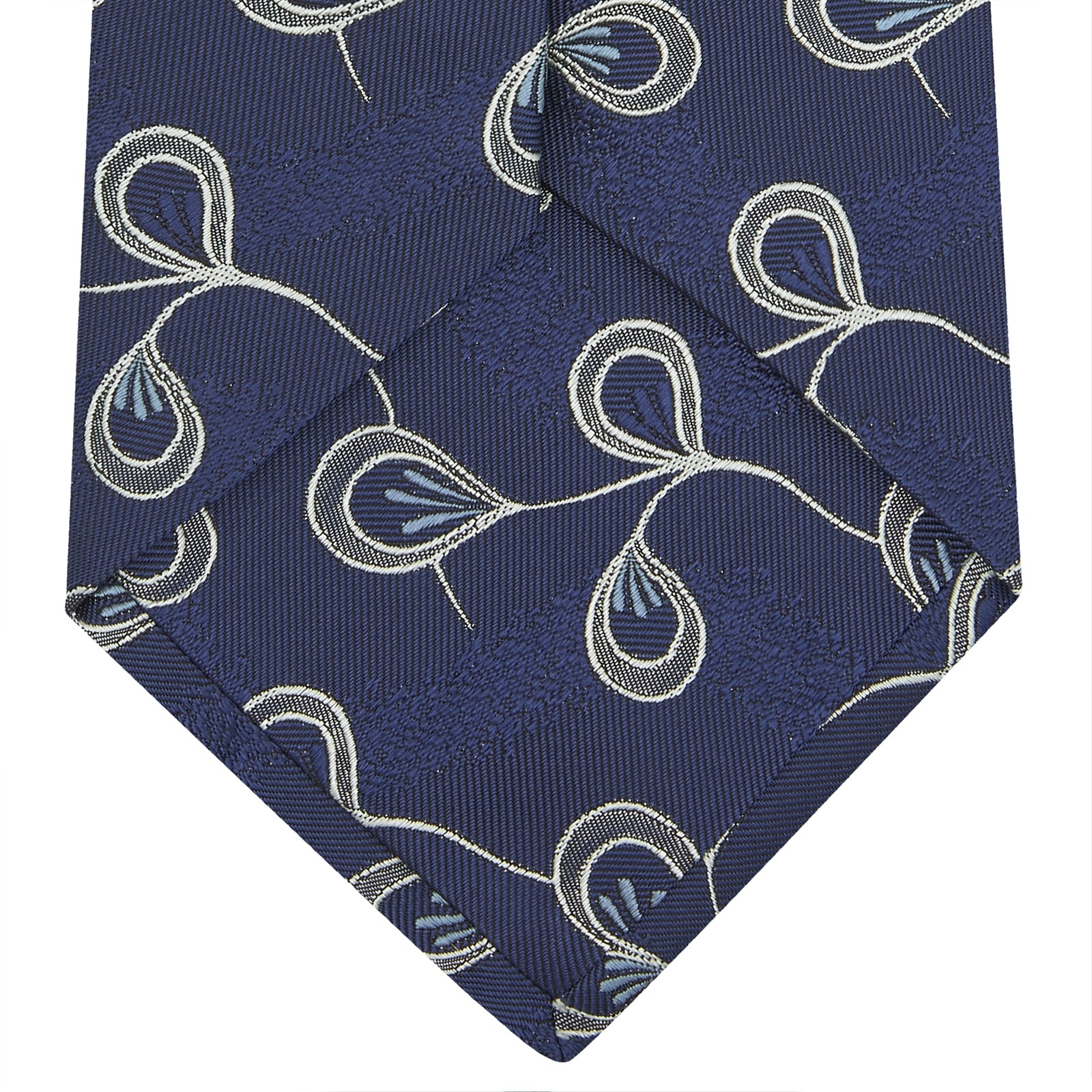 View 3 of product The Turnbull & Asser Navy Jacquard Silk Floral Tie features white and light blue abstract leaf designs, exemplifying fine British craftsmanship. Shown rolled up against a white background.