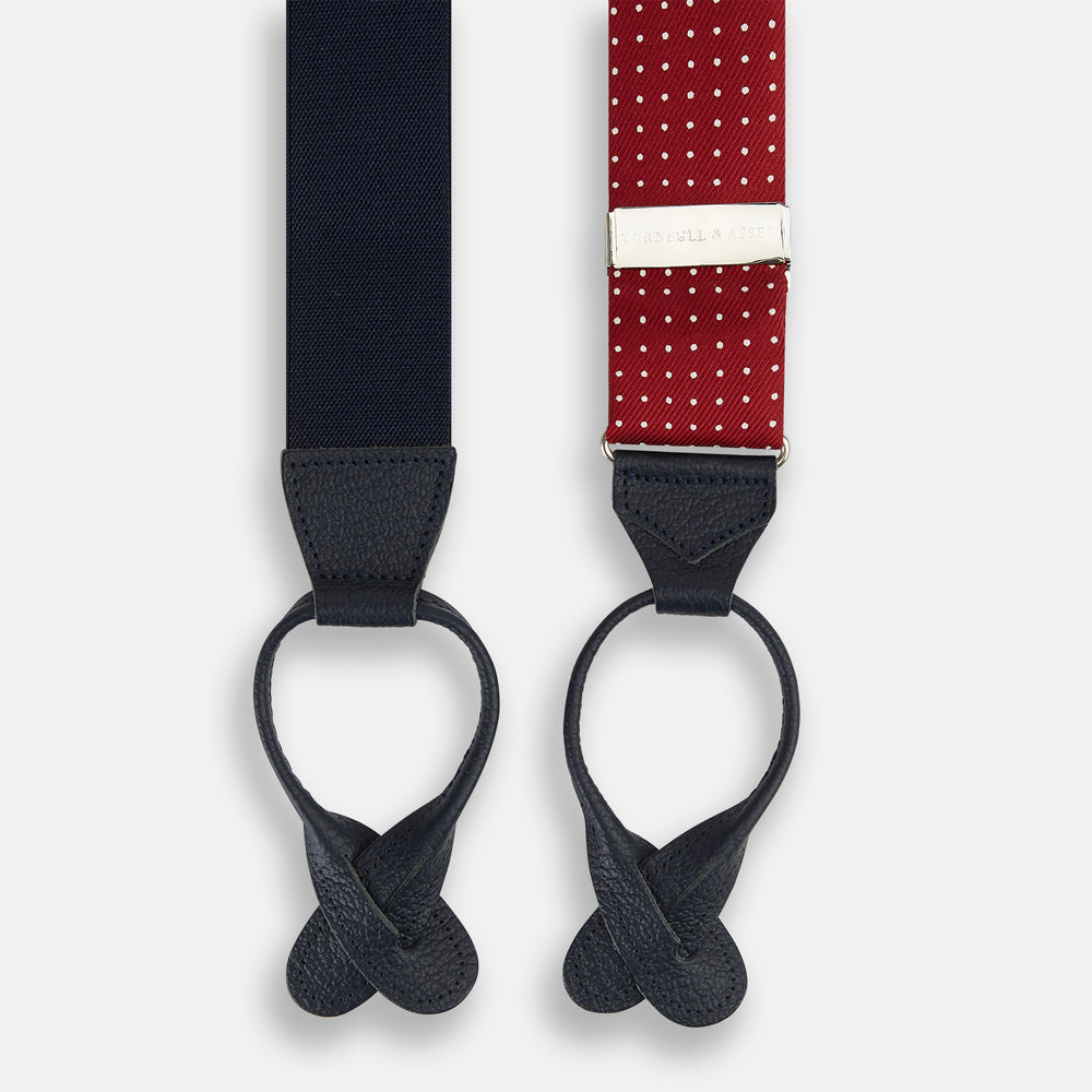 Turnbull & Asser’s Burgundy and White Small Spot Adjustable Silk and Navy Leather Braces feature white polka dots, navy leather loops, and M-shaped elastic straps—a refined statement for standout style.