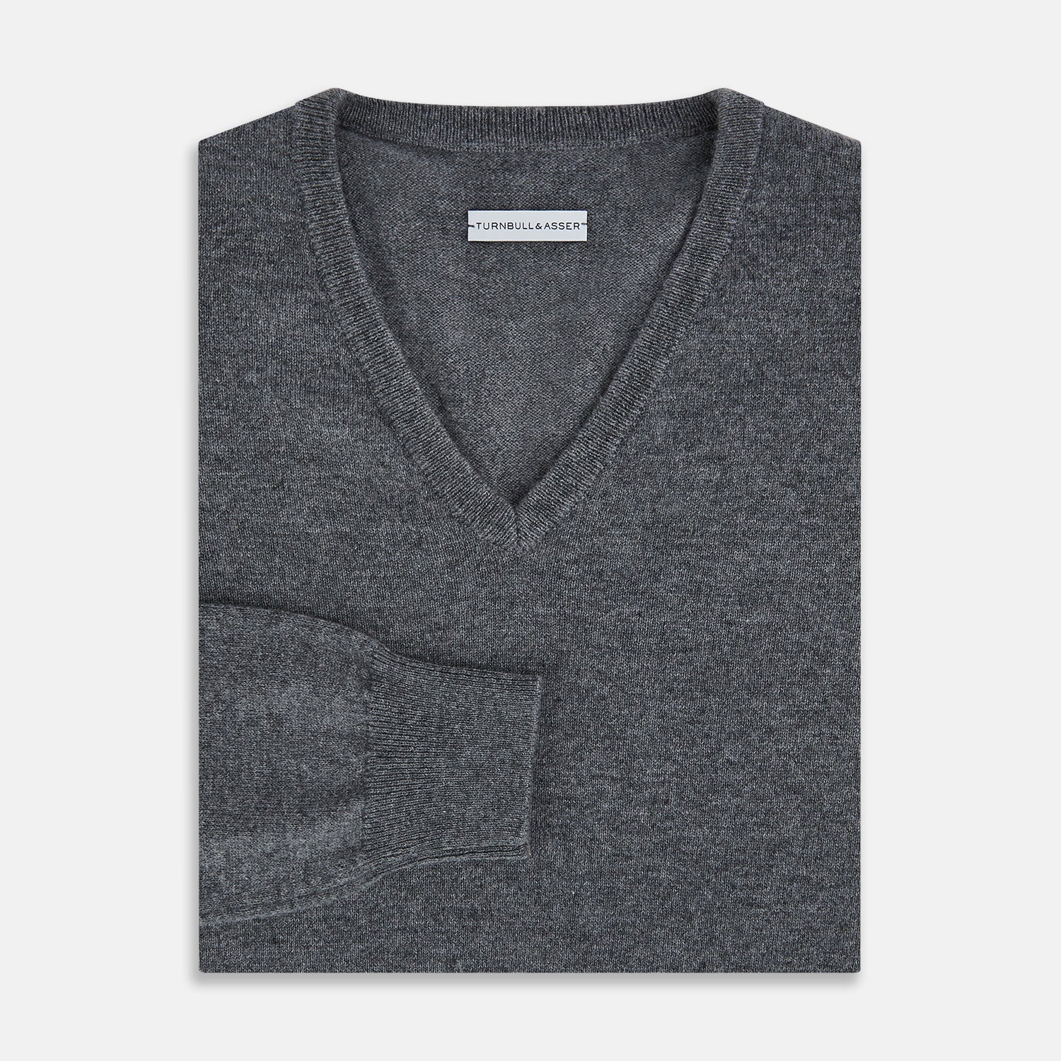 View 4 of product The Turnbull & Asser Storm Grey Cashmere V-neck Jumper features long sleeves, ribbed cuffs and hem—versatile knitwear shown on a white backdrop.