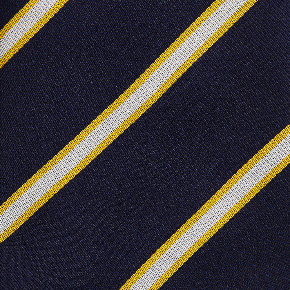 The Yellow and White Blazer Silk Tie by Turnbull & Asser, featuring diagonal white and yellow stripes on navy blue, is shown rolled up against a light gray background.