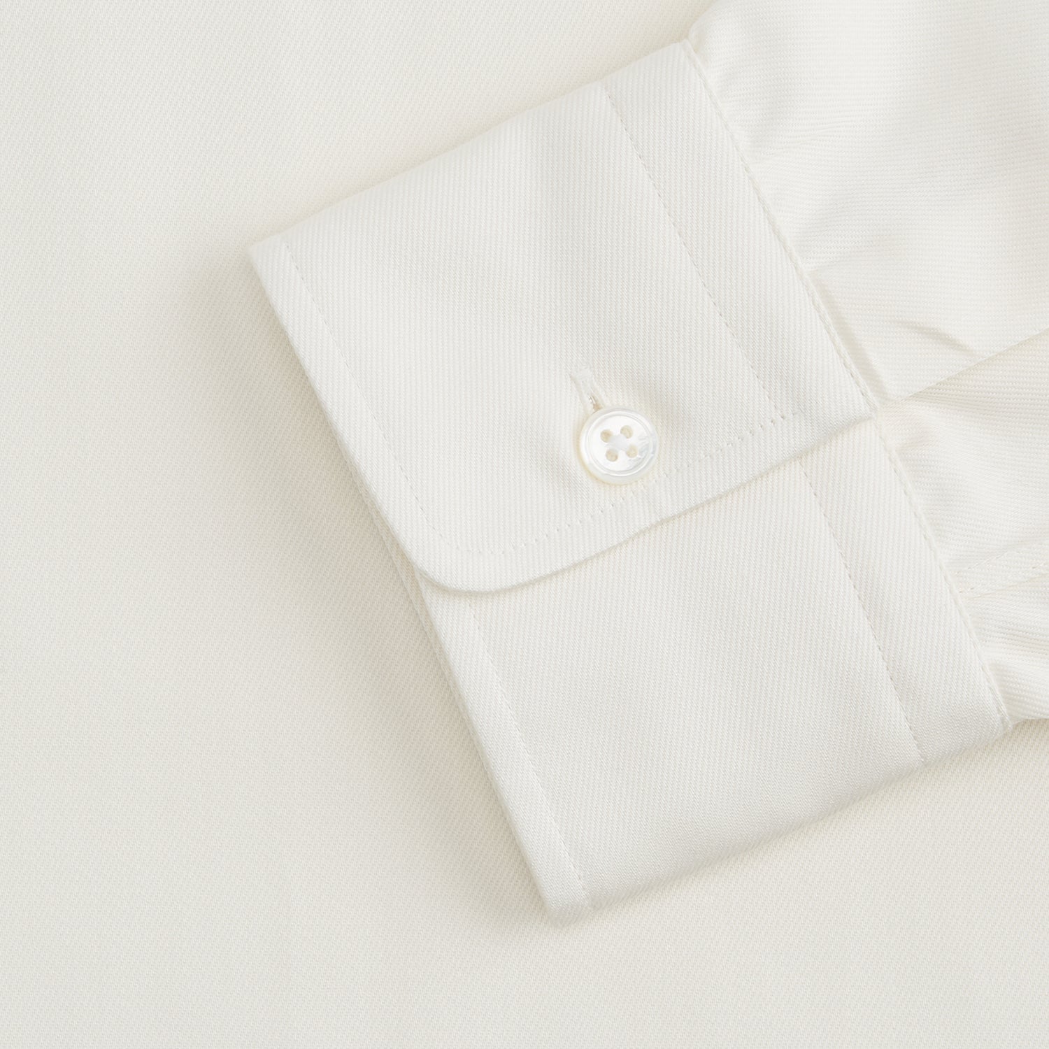 View 4 of product The Turnbull & Asser Cream Cotton Weekend Fit Unwin Shirt features long sleeves, a stand collar, and two chest pockets, shown laid flat on a white background.