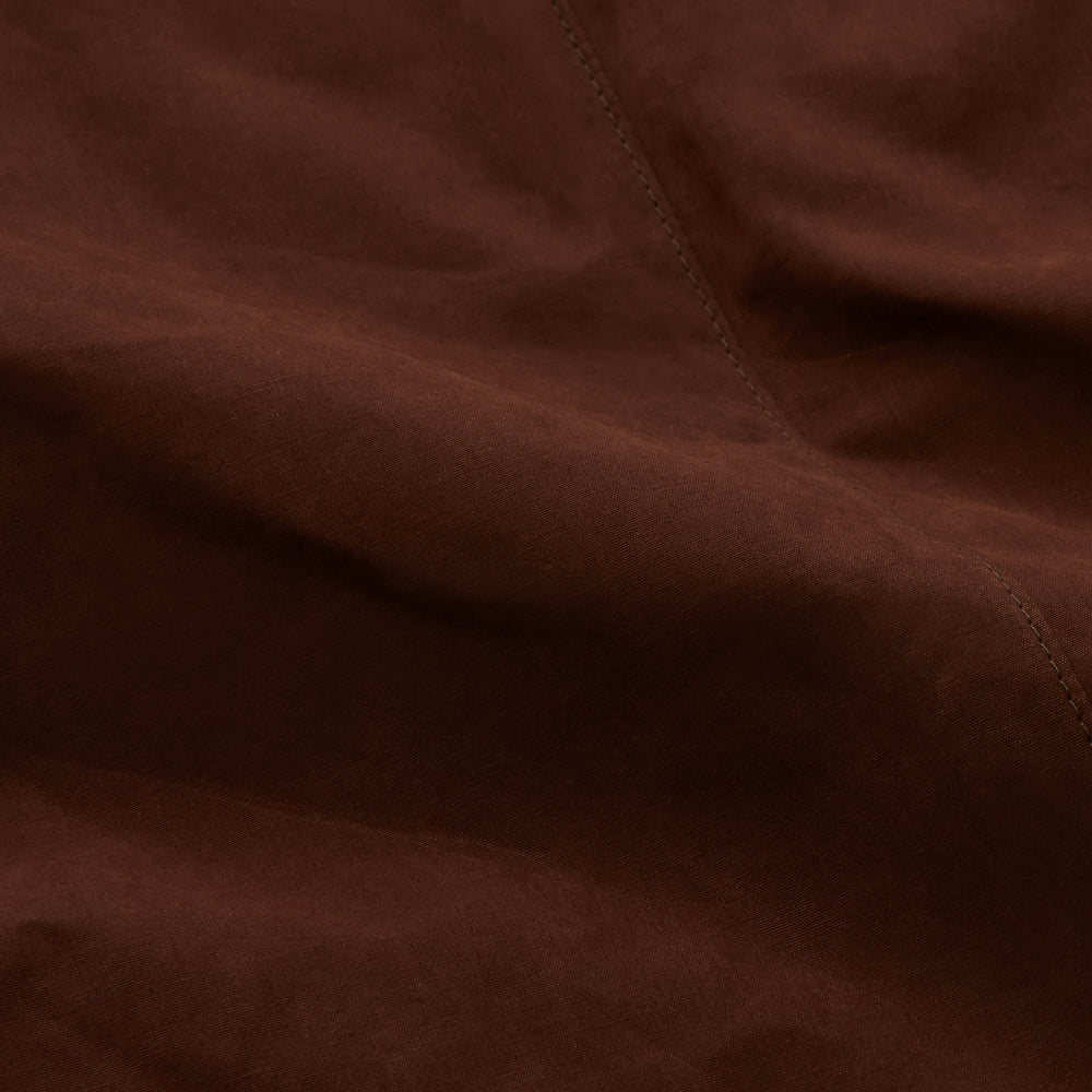The Burgundy Grayson Car Coat by Turnbull & Asser, made from a rain-resistant cotton blend with a collar, hidden front buttons, and slanted pockets, is displayed flat on a white background in a minimalist style.
