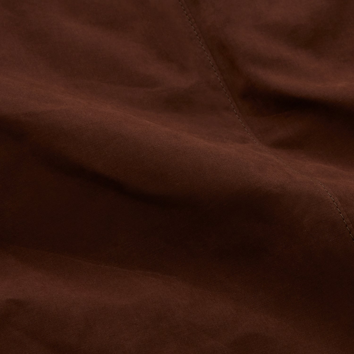 View 6 of product The Burgundy Grayson Car Coat by Turnbull & Asser, made from a rain-resistant cotton blend with a collar, hidden front buttons, and slanted pockets, is displayed flat on a white background in a minimalist style.