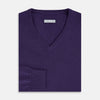 View 4 of product The Turnbull & Asser Purple Cashmere V-neck Jumper features long sleeves with ribbed cuffs and hem—a classic knitwear piece for effortless layering, shown against a white background.