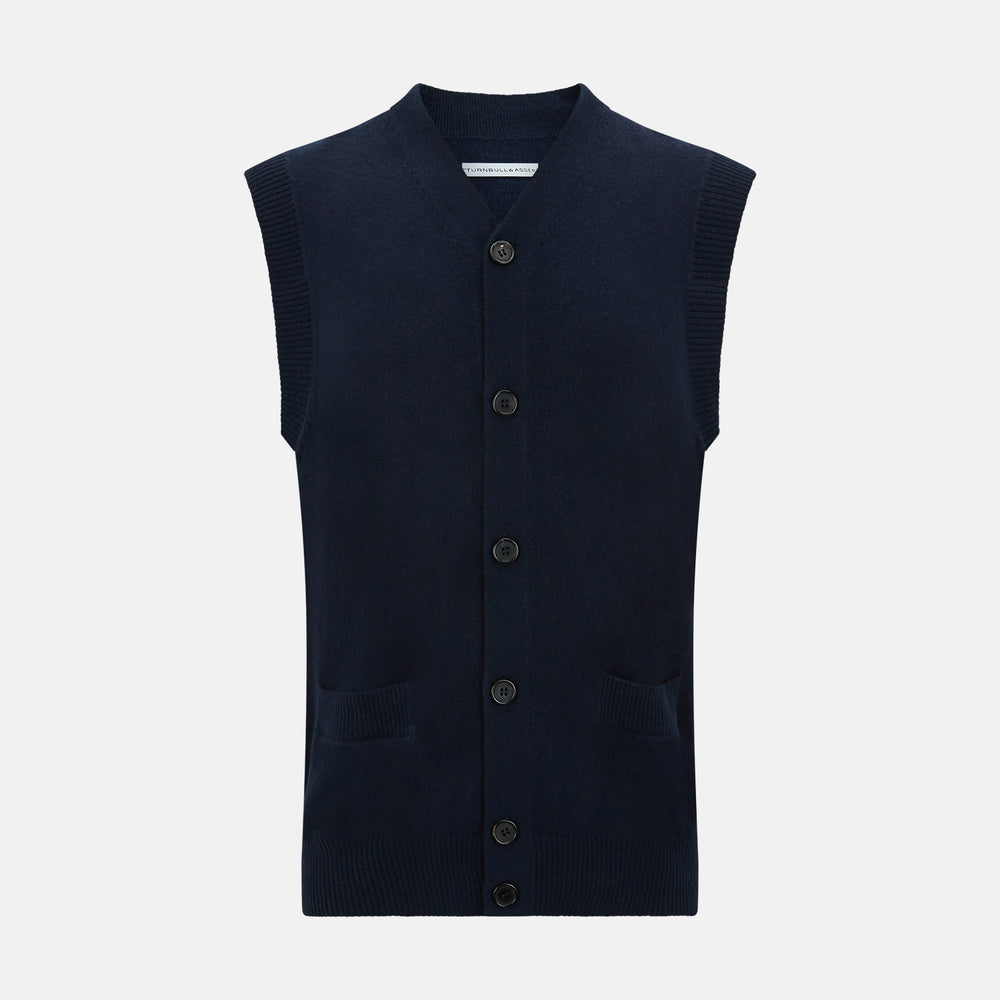 The Turnbull & Asser Navy Cashmere V-neck Sleeveless Cardigan features a button-up closure and two front pockets, ideal for elegant, gentleman-inspired looks, shown on a plain white background.