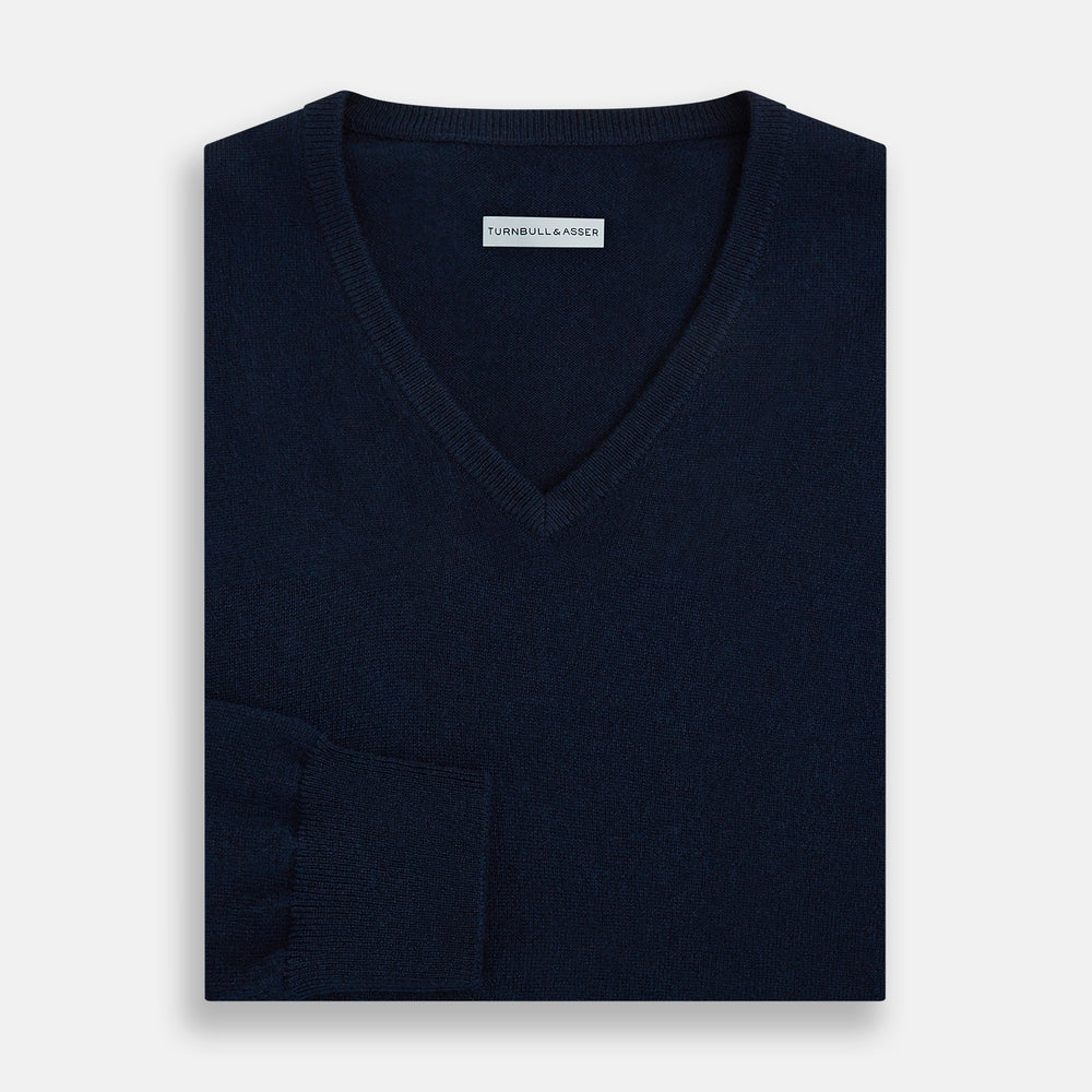 The Turnbull & Asser Navy Cashmere V-neck Jumper features long sleeves with ribbed cuffs and hem, shown against a white background.