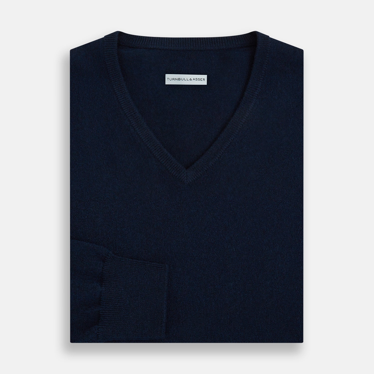 View 4 of product The Turnbull & Asser Navy Cashmere V-neck Jumper features long sleeves with ribbed cuffs and hem, shown against a white background.
