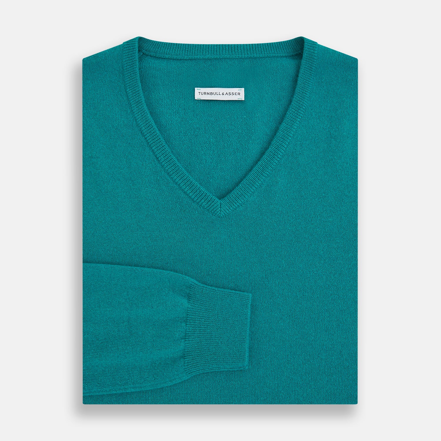 View 4 of product The Turnbull & Asser Turquoise Cashmere V-neck Jumper features long sleeves with ribbed cuffs and hem, displayed on a plain white background—a chic knitwear addition.