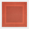 View 4 of product The Orange Dot Silk Pocket Square by Turnbull & Asser is handmade in England from silk, featuring small black polka dots and a solid orange border with a folded corner.