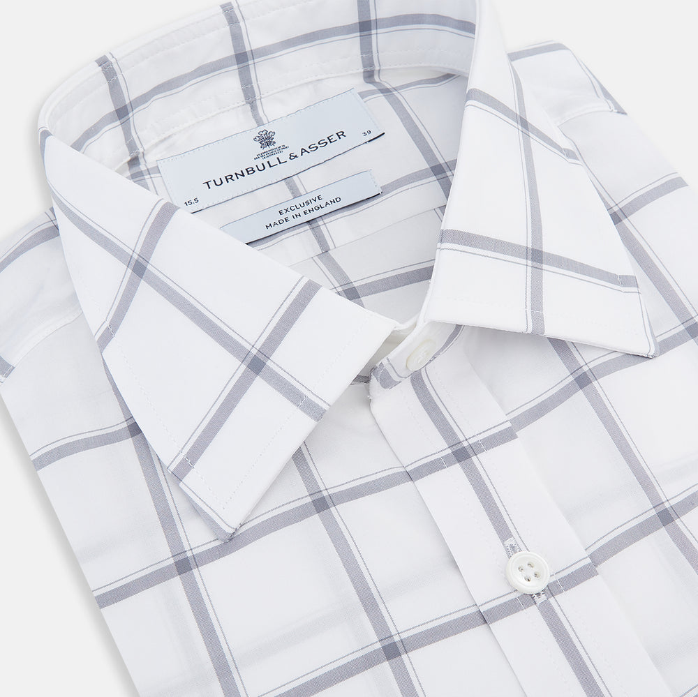 The Turnbull & Asser Grey Grid Check Mayfair Shirt features a classic collar and buttoned cuffs, crafted from fine Italian cotton with a grey grid check on white, and is shown against a plain white background.