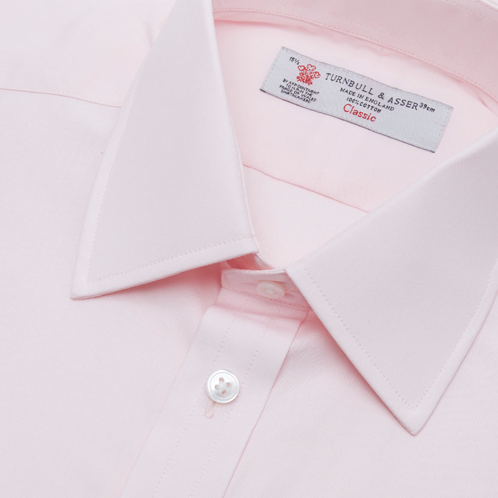 A Turnbull & Asser Pink Cotton Shirt with a T&A collar and double cuffs is displayed against a white background. The men's shirt features long sleeves, white buttons, and the label is visible inside the collar.
