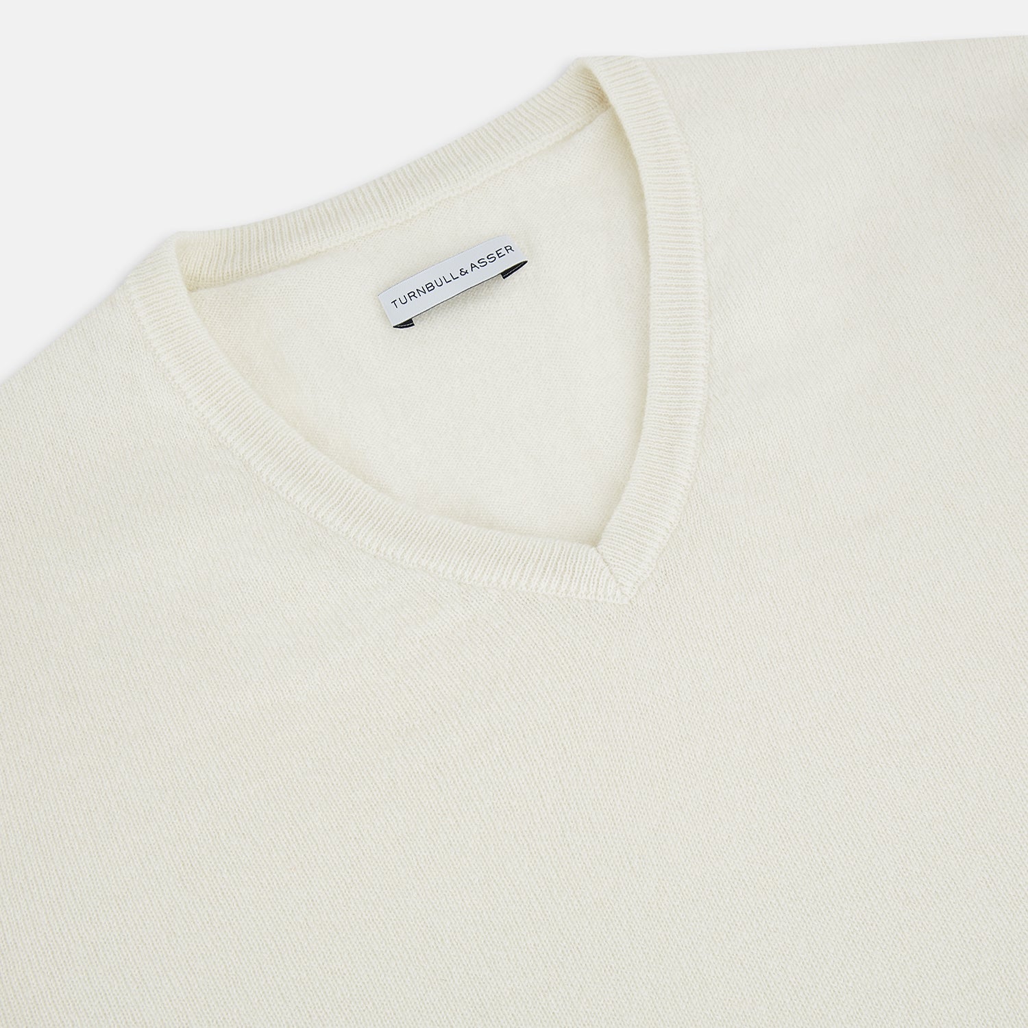 View 2 of product The Turnbull & Asser White Cashmere V-Neck Jumper features long sleeves and a versatile light cream shade, making it a timeless addition to your knitwear collection.