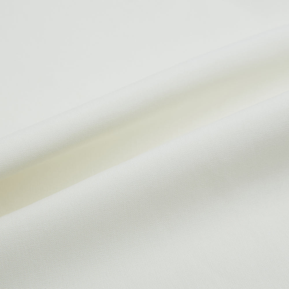 The Turnbull & Asser Cream Silk Pyjama Set, shown laid flat on a white background, features a long-sleeve button-up top with a chest pocket and matching pants with an elastic drawstring waist—ideal for comfortable loungewear.