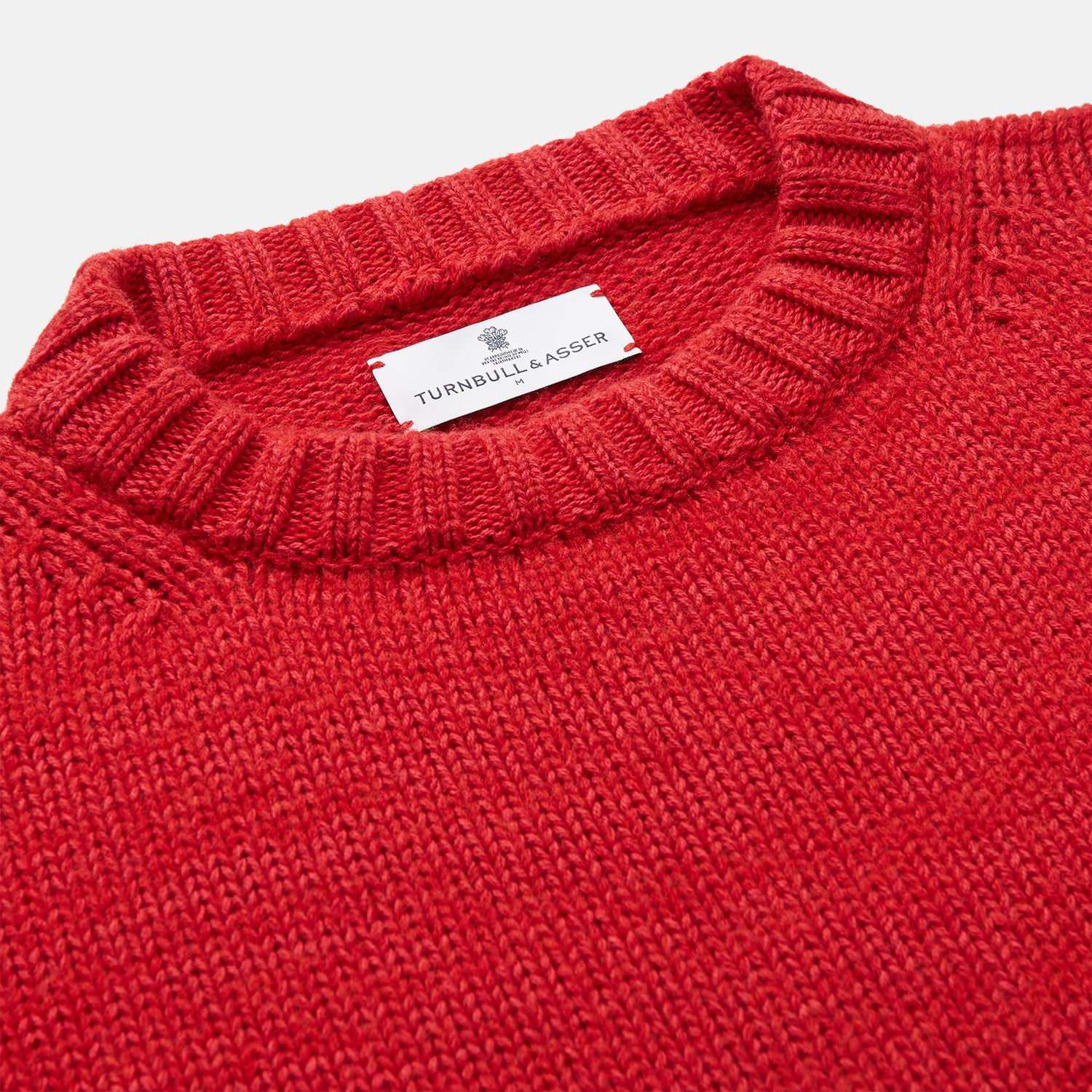 View 3 of product The Red Lewis Guernsey Knitted Jumper by Turnbull & Asser is a bright red wool-cotton, long-sleeve jumper with a round neckline, ribbed cuffs, and ribbed hem, shown against a white background.