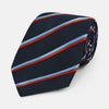 View 1 of product The Turnbull & Asser Red And Blue Stripe Silk Blend Tie, rolled on a white background, features refined diagonal accents—an elegant formal accessory.