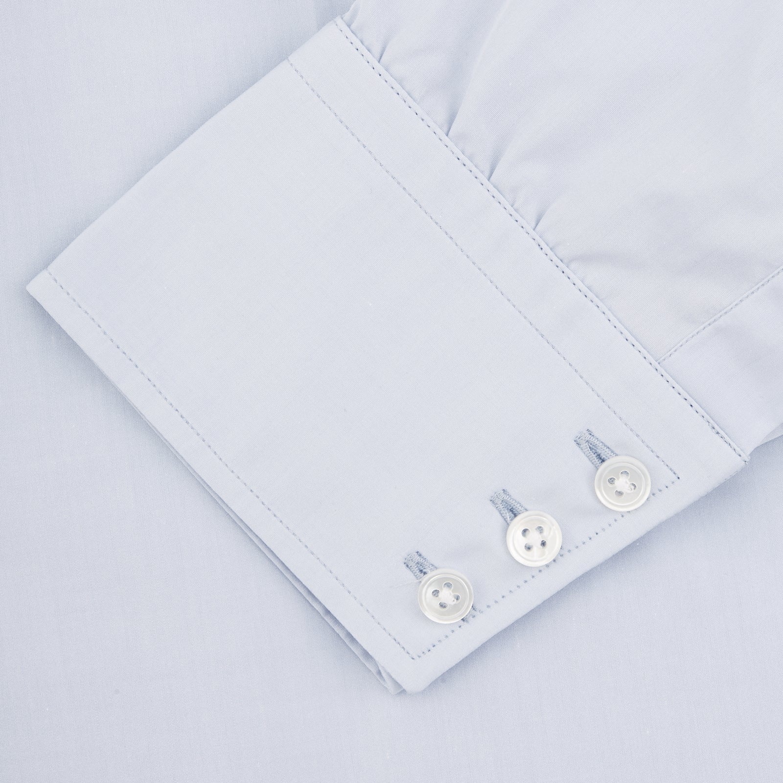 View 3 of product The Turnbull & Asser Two-Fold 120 Light Blue Shirt features a T&A collar, 3-button cuffs, white buttons, front pocket, and inner collar label. It is displayed neatly folded on a plain white background.