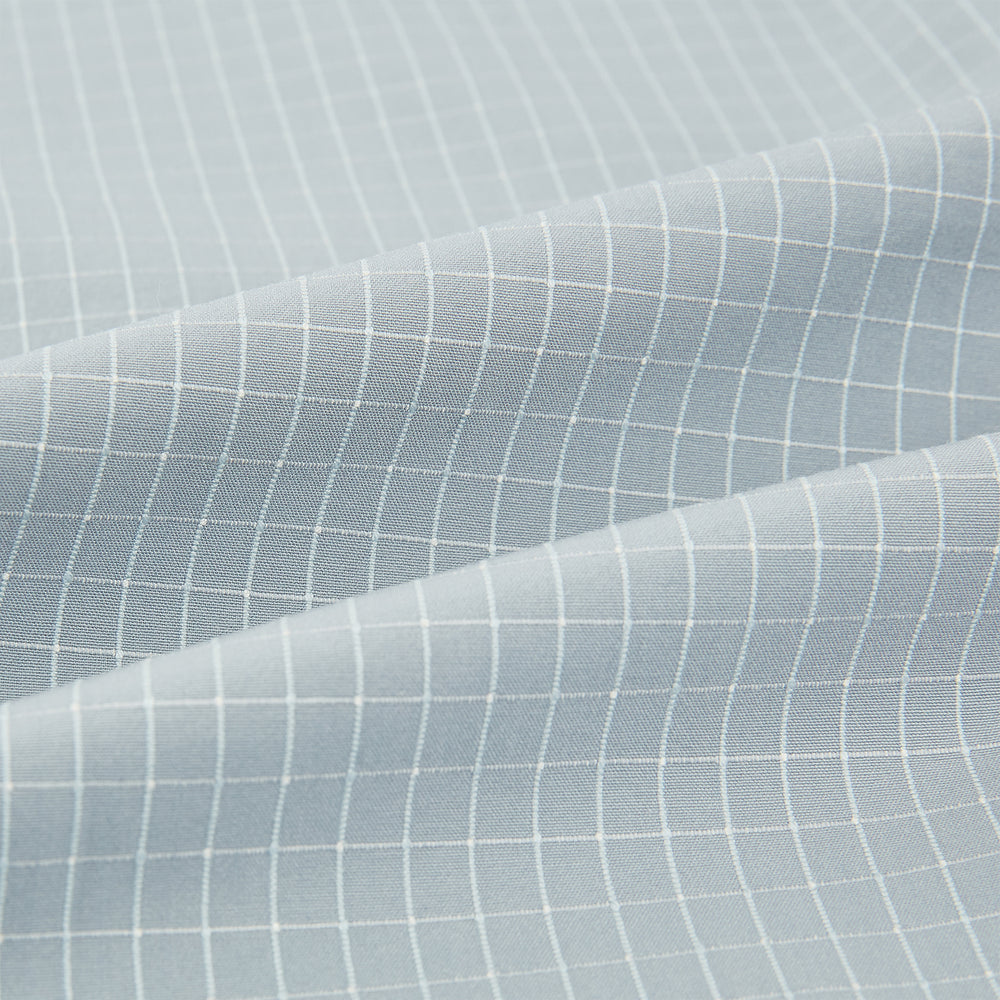 Turnbull & Asser Pale Blue Fine Check Mayfair Shirt—a long-sleeve button-up with classic collar, buttoned cuffs, white buttons, and a subtle check pattern in sanforised cotton—displayed on a white background.