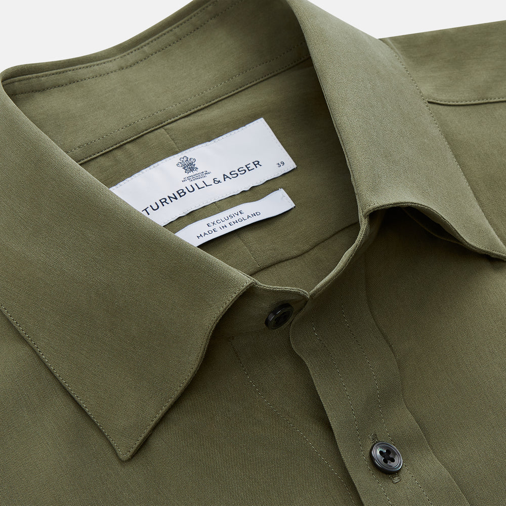The Turnbull & Asser Green Silk Regular Fit Flaxton Shirt features long sleeves, a classic Bury collar, white buttons, and a straight hem, shown against a plain white background.