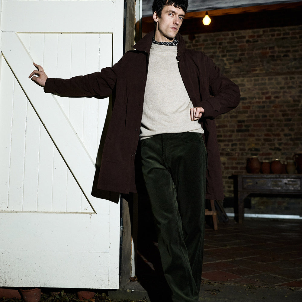 The Burgundy Grayson Car Coat by Turnbull & Asser, made from a rain-resistant cotton blend with a collar, hidden front buttons, and slanted pockets, is displayed flat on a white background in a minimalist style.