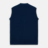 View 5 of product A man with a shaved head wears a Turnbull & Asser Navy Sleeveless Cashmere Cardigan over a white dress shirt with rolled-up sleeves and dark trousers, standing against a plain light gray background.