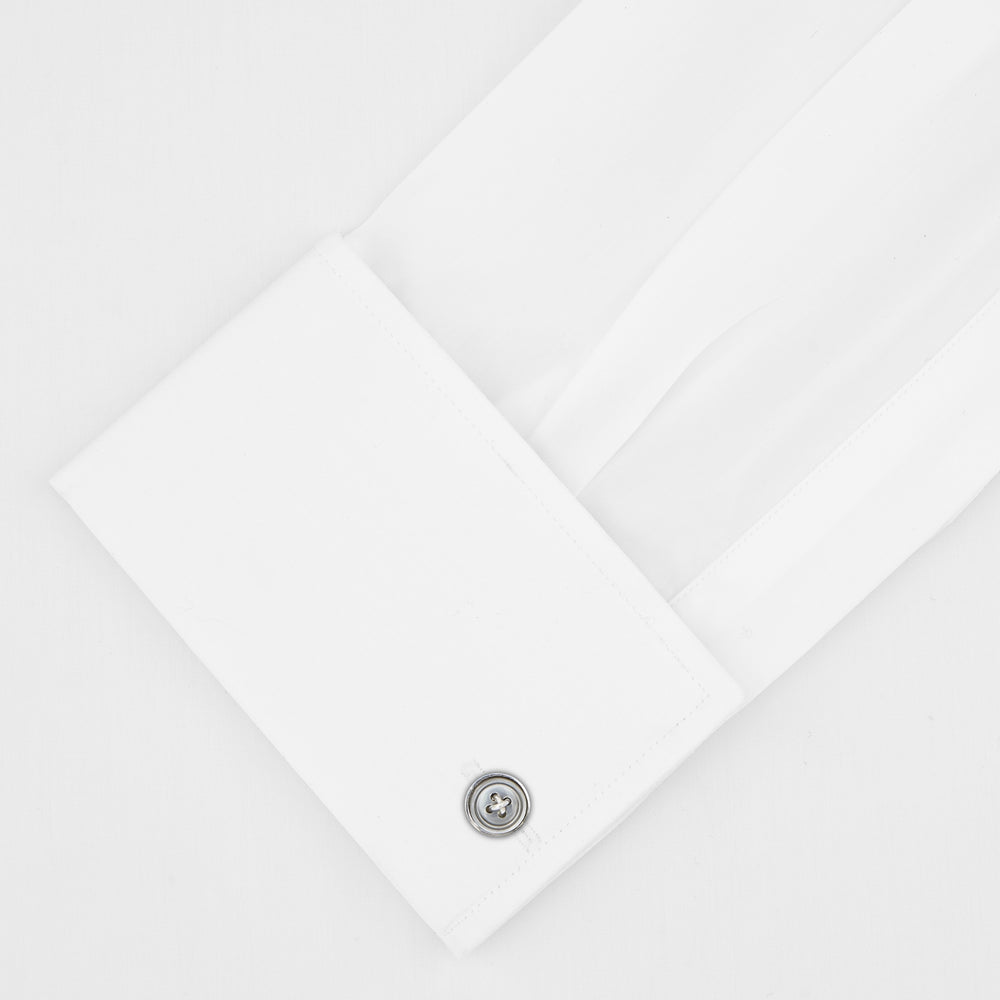 The Turnbull & Asser Tailored Fit Two-Fold 120 White Cotton Shirt features a Kent collar, double cuffs, and button-down front, displayed neatly folded against a light blue background.