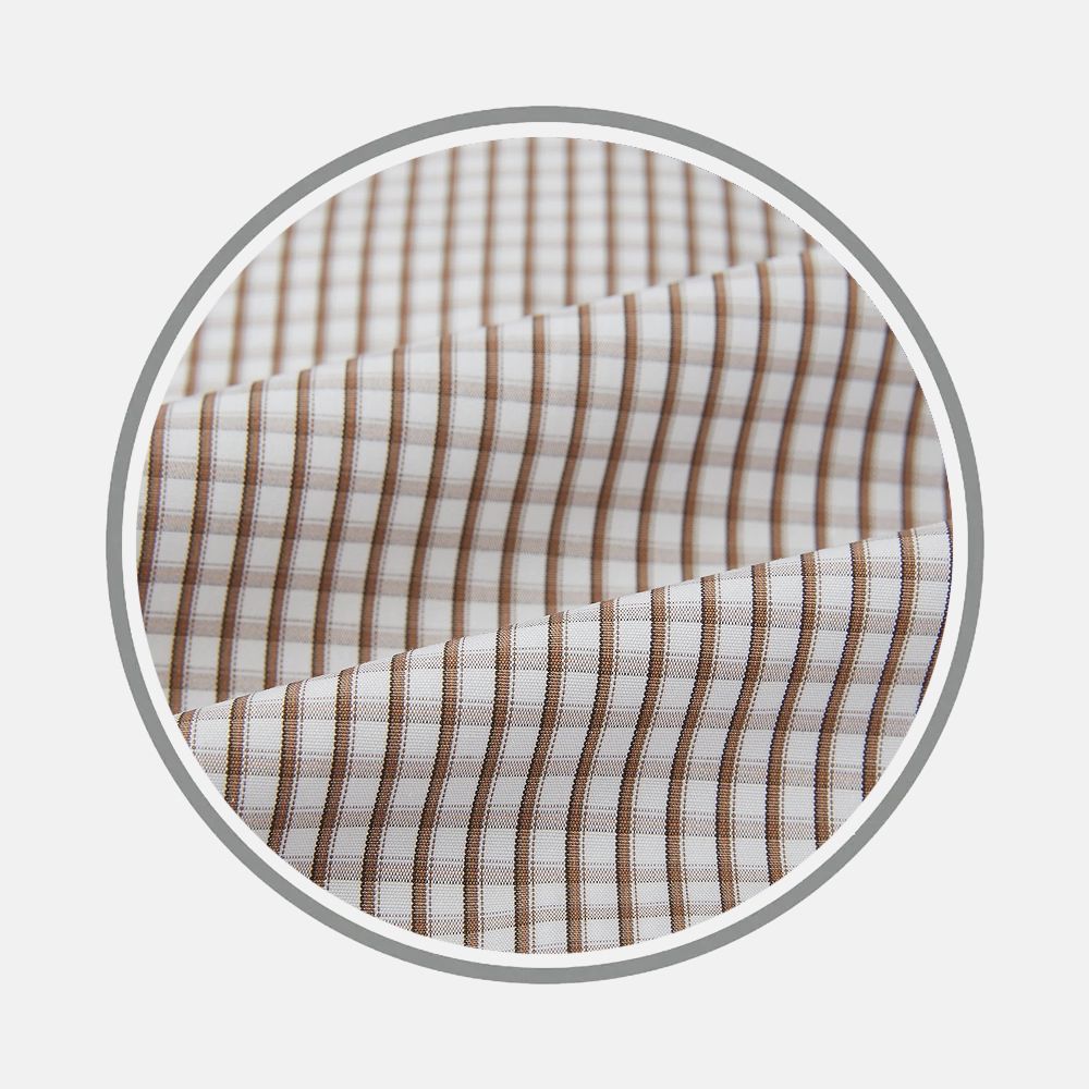 A close-up of Turnbull & Asser’s Coffee Micro Shadow Check Fabric shows its brown and beige checkered pattern with precise stripes, displayed slightly folded within a circular frame on a light background.
