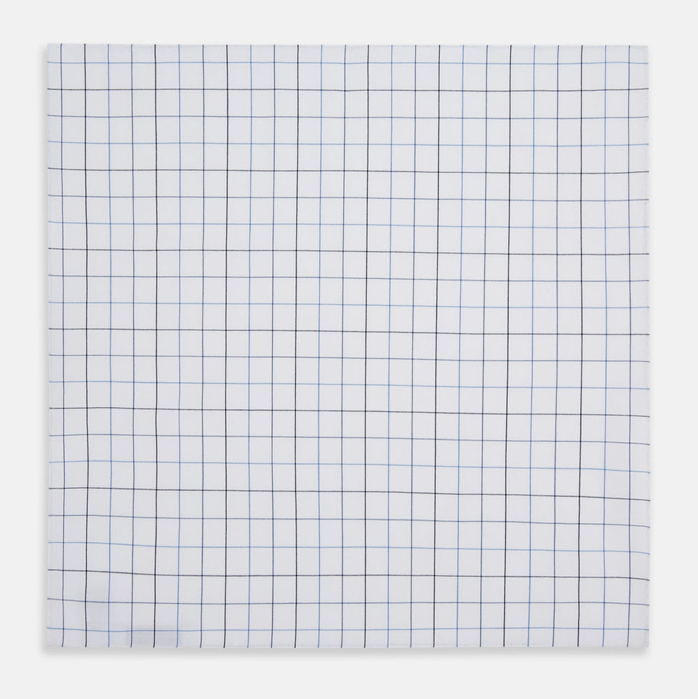 The Turnbull & Asser Hand Rolled Blue Grid Check Handkerchief features a classic blue and black grid on white cotton, neatly folded—a timeless gentleman's accessory.