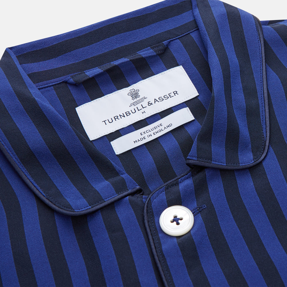 The Turnbull & Asser Blue and Navy Candy Stripe Silk Hyde Pyjamas Set features a long-sleeve button-up top with a chest pocket and elastic-waist pants, shown on a plain white background.