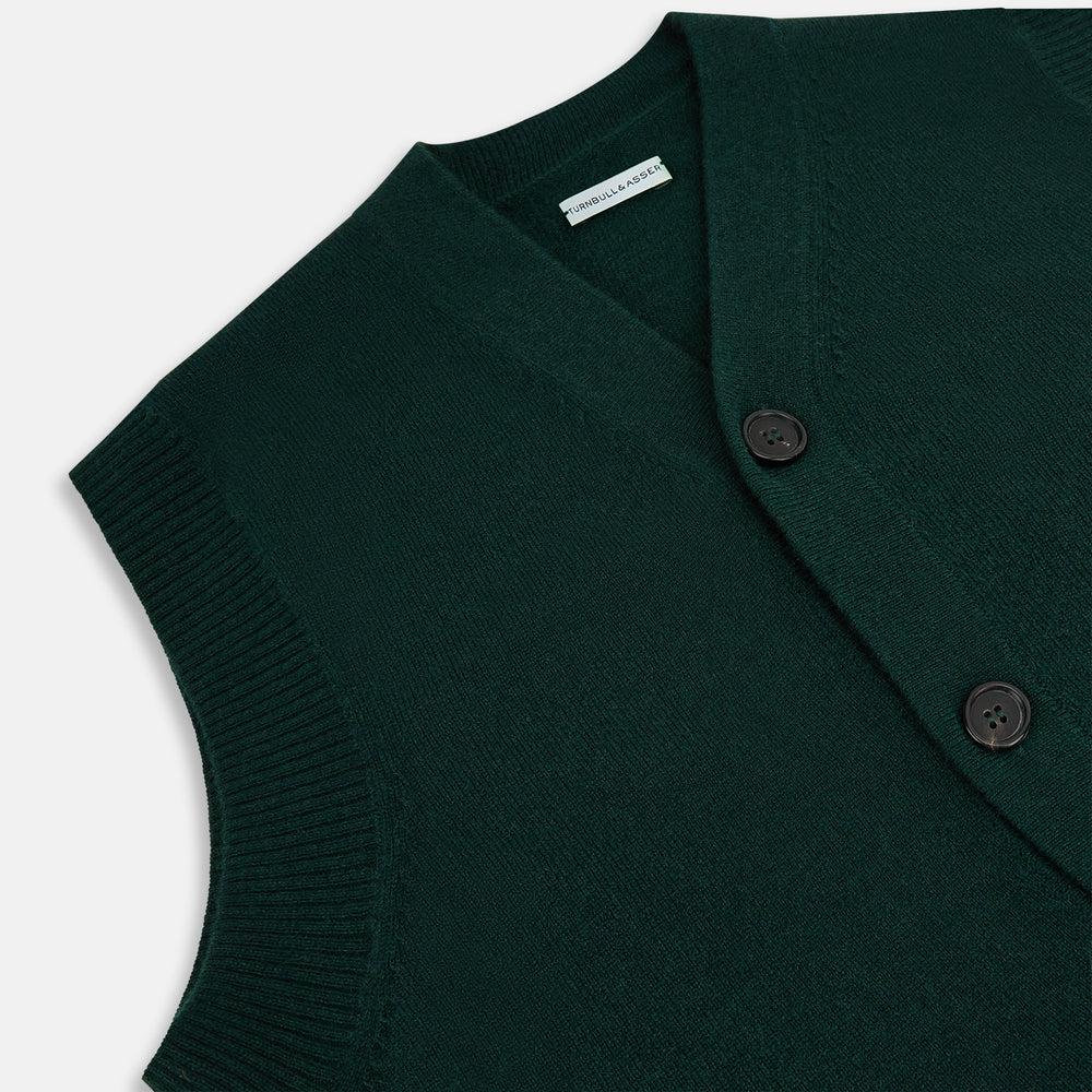 The Forest Green Cashmere Sleeveless Cardigan by Turnbull & Asser features a V-neck, button-down front, ribbed hem and armholes, and two front pockets—an elegant menswear staple shown on a plain white background.