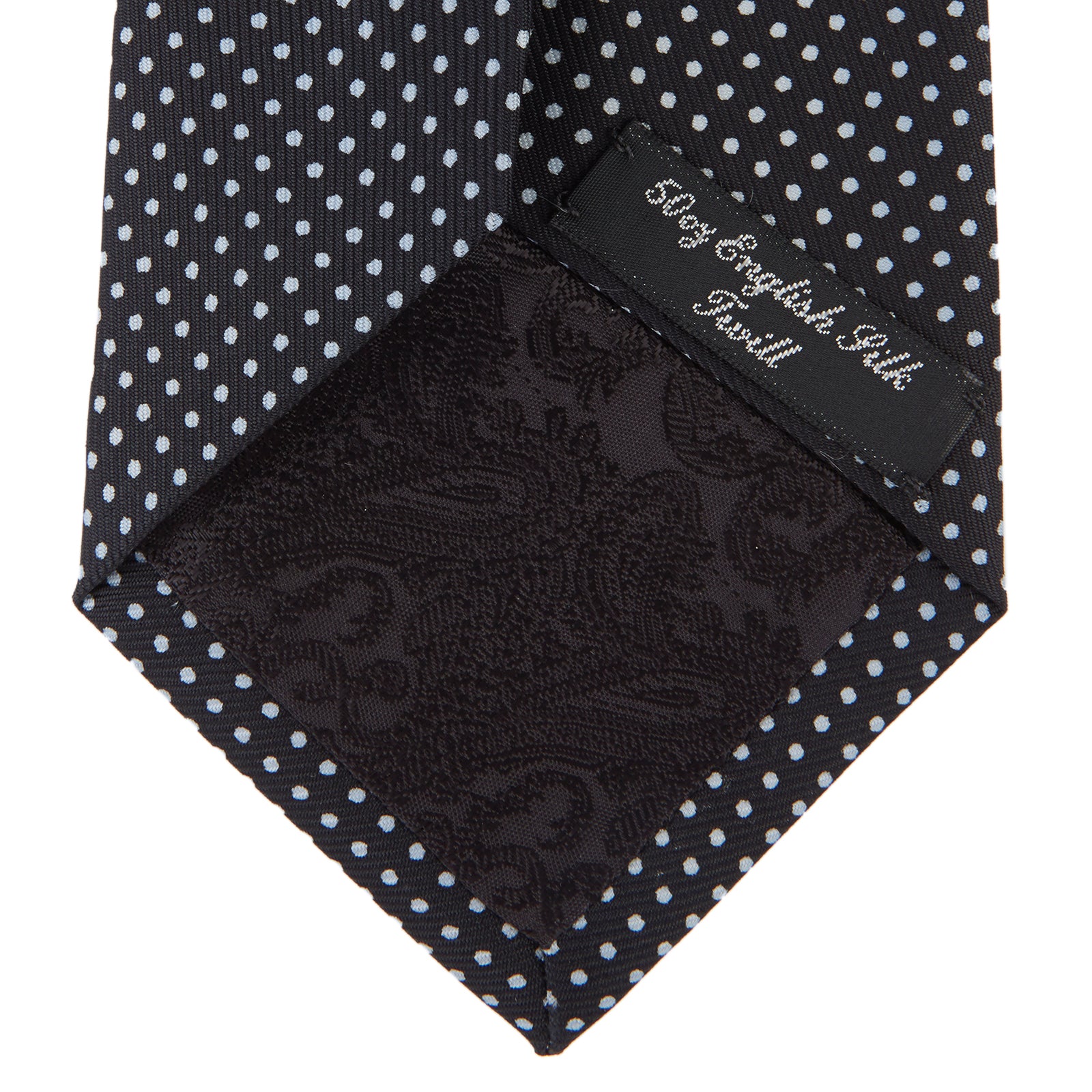 View 4 of product The Turnbull & Asser Black and White Small Spot Printed Silk Tie, shown rolled against a white background, features a subtle polka dot pattern—an ideal accessory for any office shirt.