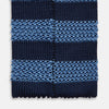 View 4 of product The Turnbull & Asser Navy and Blue Square tipped knitted tie features horizontal stripes and a rolled-up silk design, elegantly displayed on a plain white background.