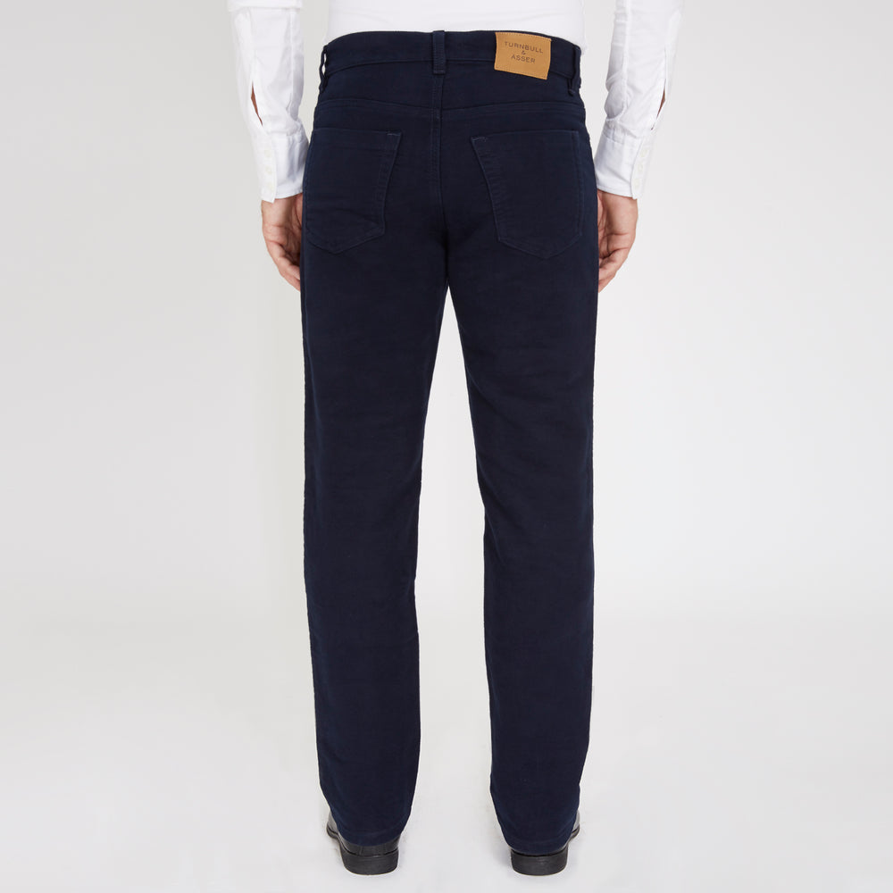 A pair of Turnbull & Asser 5 Pocket Boston Trousers, straight-leg with a dark wash, feature front and back pockets, a button closure, and belt loops, shown on a plain white background.