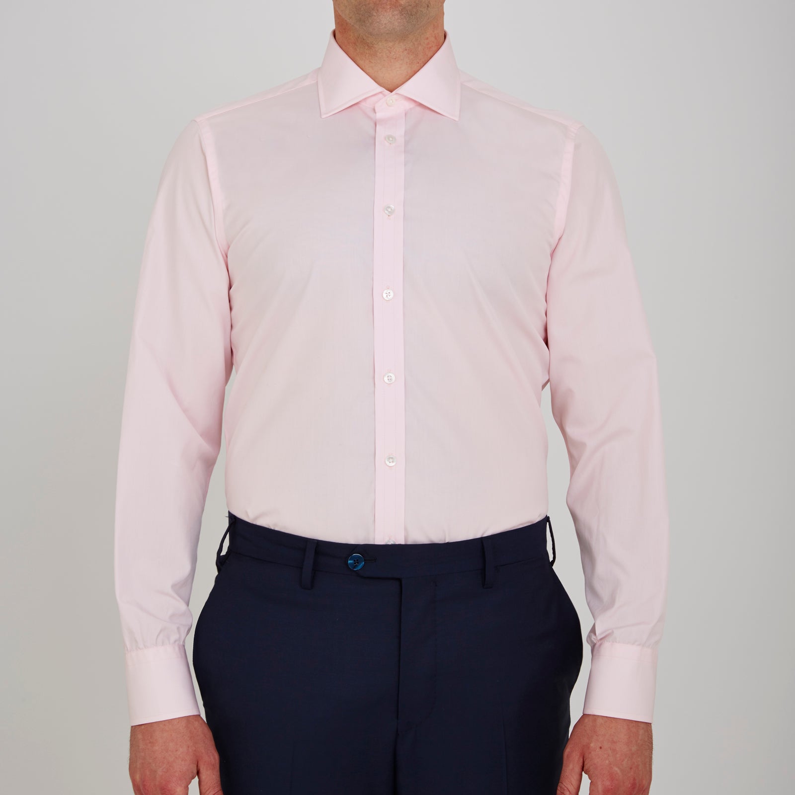 View 2 of product The Turnbull & Asser Pink Poplin Slim Fit Regent Collar Shirt features white buttons and a slim fit label, neatly folded and displayed on a plain white background.